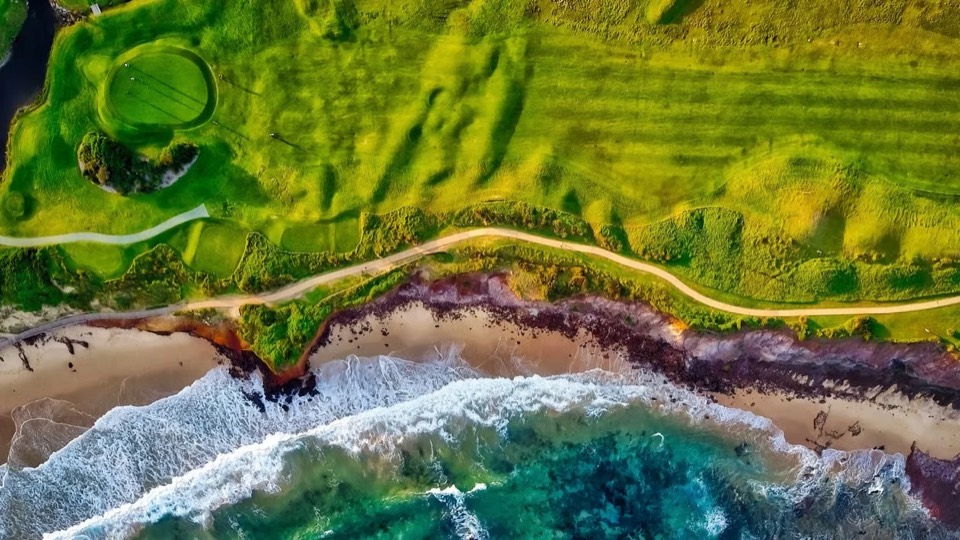 Aerial view of a coastal golf hole with a green and fairway beside the ocean