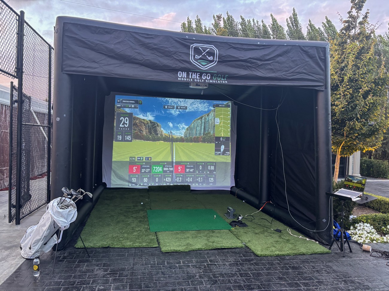 Mobile golf simulator set up at a backyard event in Langley, impact screen lit up mid-shot
