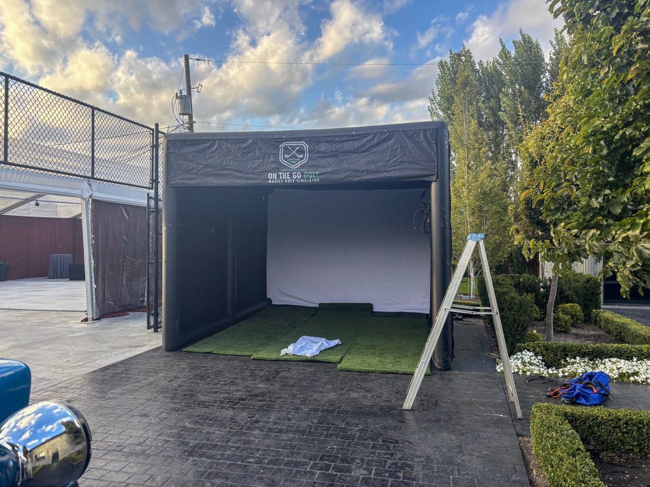 Inflatable golf simulator enclosure set up on a patio before guests arrive
